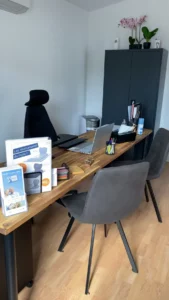 Bureau d'accueil de pompes funèbres équipé d'un ordinateur et de brochures.