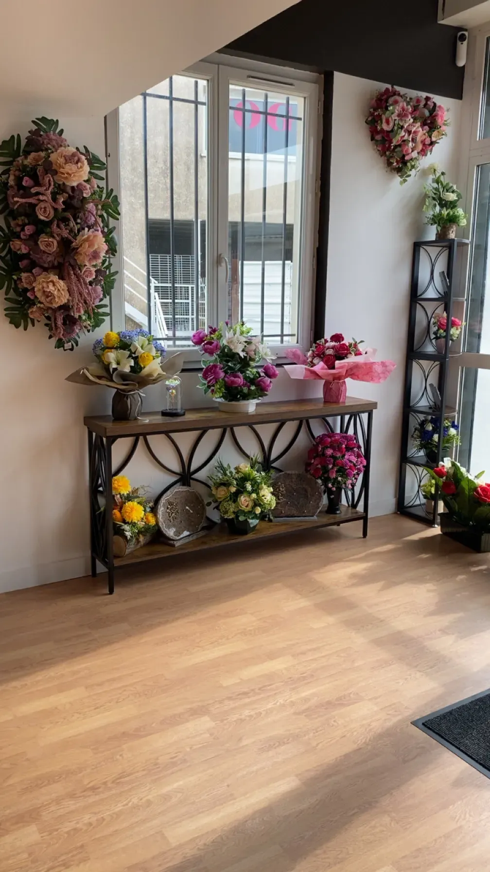 Exposition de fleurs deuil et plaques funéraires sur un meuble dans une agence de pompes funèbres.